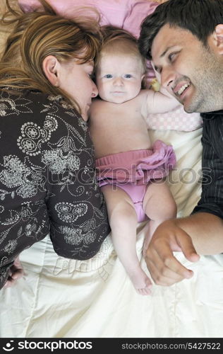 indoor portrait with happy young family and cute little babby