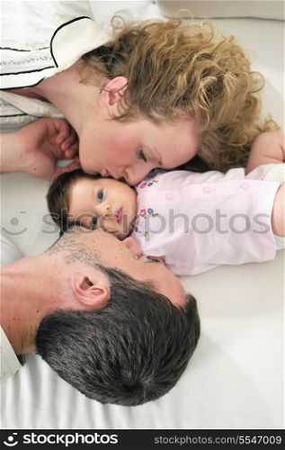 indoor portrait with happy young family and cute little babby