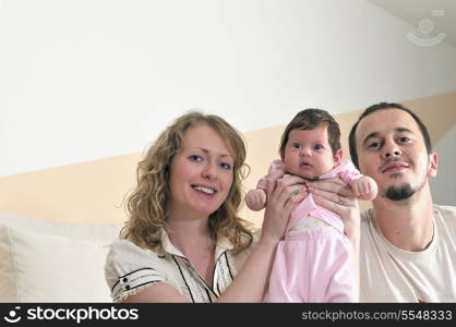 indoor portrait with happy young family and cute little babby