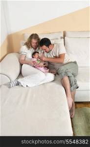 indoor portrait with happy young family and cute little babby