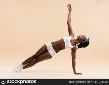 Indoor shot of a young african woman doing yoga
