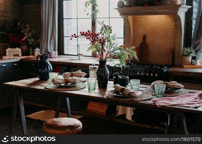 Indoor shot of served table with rolled napkins. Dinner time concept. Table setting decor. Interior of home kitchen. Rustic serving
