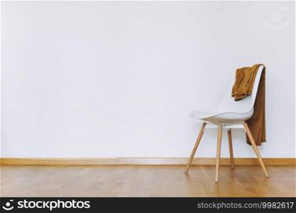 Indoors flat wall mockup with Clothes on Chair in minimalist style. Earthy Neutrals Tones Background. Interior in airy light style with wooden floor