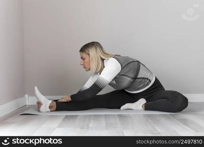indoors mature woman stretching her legs