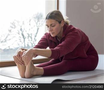 indoors mature woman touching her feet