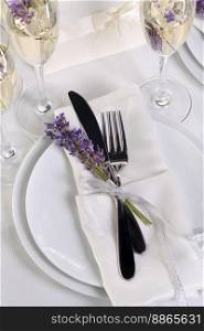 Indulge in a dose of romantic French countryside inspiration with fresh lavender, Lavender Ch&agne, a folded napkin with cutlery. Detail of the wedding dinner. Wedding theme ideas.