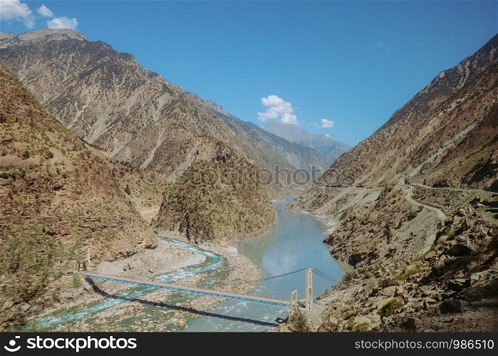 Indus river flowing through mountains in rural area of Pakistan. View from Karakoram highway.