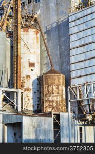 industrial background - exterior of old abandoned grain elevator with pipes, ducts, ladders and chutes