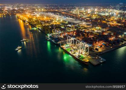 industrial business international sea freight station by large cargo containers ship above view frome drone camera at night over lighting in Thailand