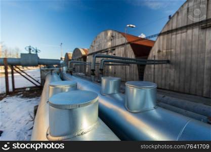 industrial concept - outdoor pipeline and old hangars in winter. outdoor pipeline and old hangars in winter