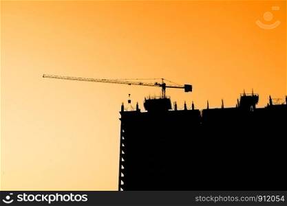 industrial construction cranes and building silhouettes sunset