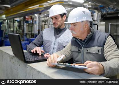 industrial engineers looking at laptop information