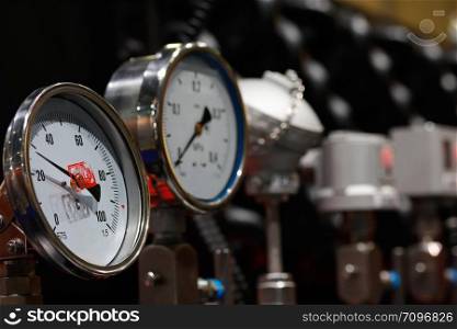 Industrial equipment with analogue every angle temperature and pressure gauges.