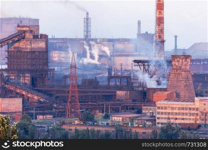 Industrial landscape in Ukraine. Steel factory at sunset. Pipes with smoke. Metallurgical plant. steelworks, iron works. Heavy industry in Europe. Air pollution from smokestacks, ecology problems.