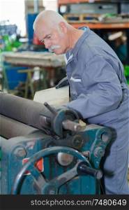 industrial man worker processing sheet metal in factory workshop