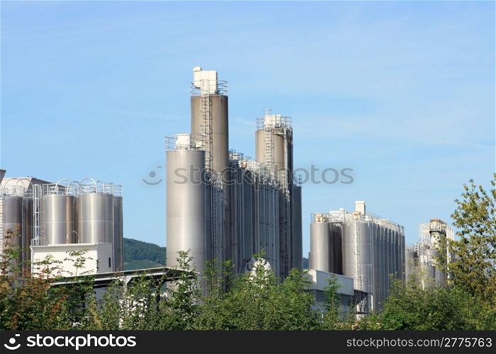 Industrial plant for chemical production, with trees and blue sky