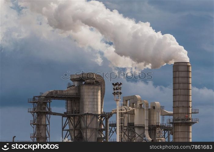 Industrial plant of a furniture factory with smoking chimneys on stormy sky