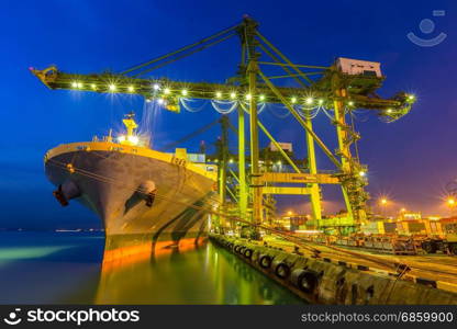 Industrial port with container ship at dusk