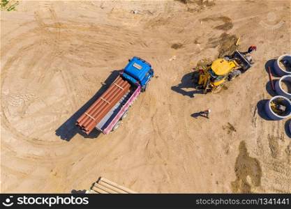 Industrial truck loader excavator moving earth and unloading. Aerial view