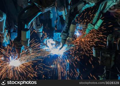 Industrial welding robots are welding in car factory