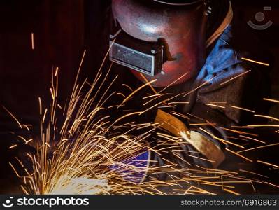 industrial worker is welding in factory