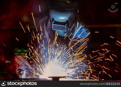 Industrial worker is welding in factory