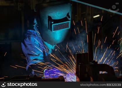 Industrial worker is welding repair metal part