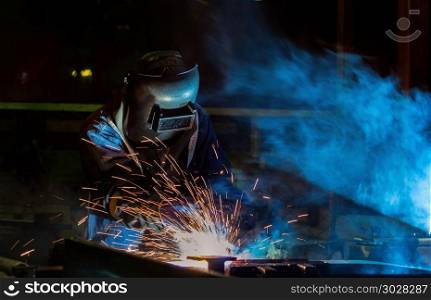 Industrial worker is welding repair metal part in car factory