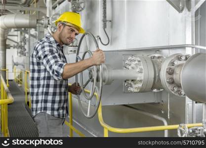 Industrial worker turning large valve