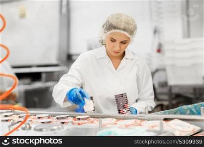 industry, food production and people concept - woman working at ice cream factory conveyor. woman working at ice cream factory conveyor