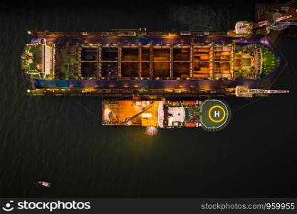 industry shipyard and repairing large ships in the sea aerial view at night over lighting in Thailand