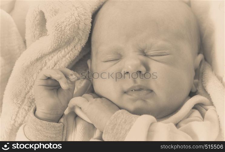 Infant care, beauty of childhood concept. Little newborn baby sleeping calmly in bed surrounded with blankets. Little newborn baby sleeping calmly in blanket