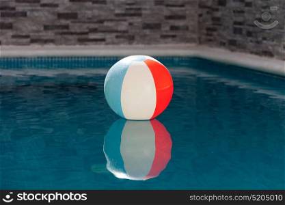 Inflatable ball in a pool on the blue water