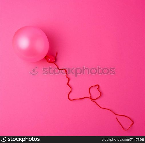 Inflated pink air balloon on the pink background, close up