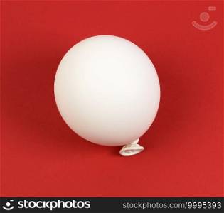 inflated white balloon on a red background, top view