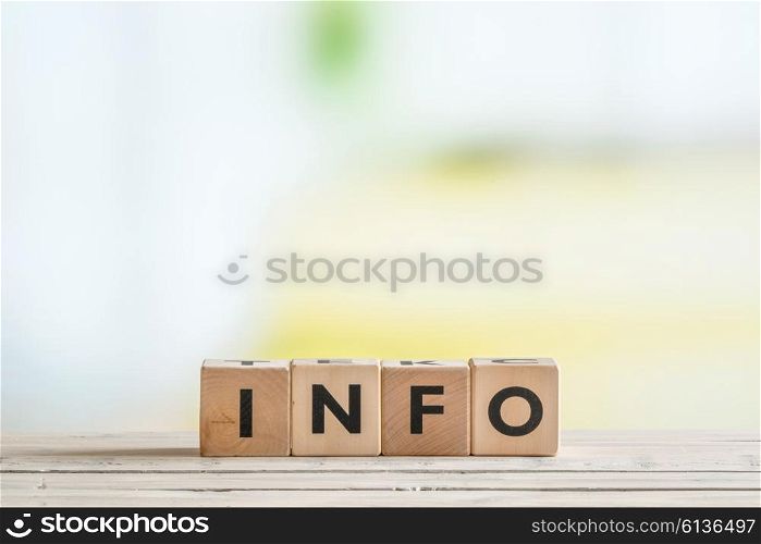 Info sign made of wooden cubes on a desk