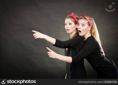 Information and messages. Two blonde pin up retro style women showing something interesting by their fingers. Vintage girls body language.. Pin up vintage ladys showing one direction.