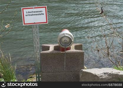 Information board with the inscription in German fire water extraction point. Firefighting Equipment in a river.