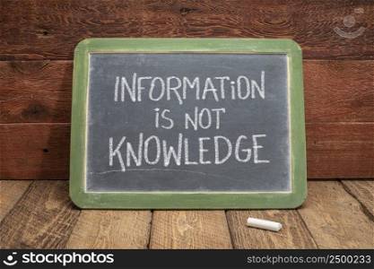 information is not knowledge"e - white chalk text on a vintage slate blackboard against rustic wood, education, science and communication concept