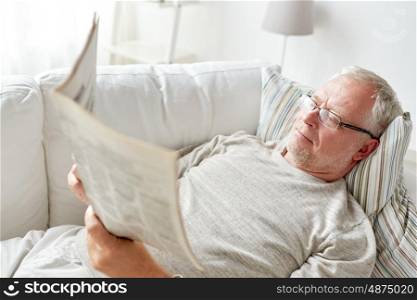 information, people, and mass media concept - close up of senior man reading newspaper at home