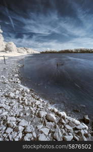 Infrared landscape of lake in English countryside in Summer with surreal colors