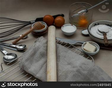 Ingredients and kitchen items for baking cakes. flour, eggs, butter, milk and honey on light brown table. Baking background. Selective focus.