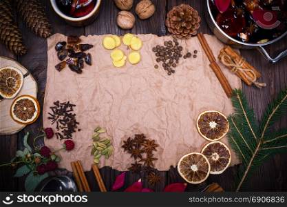 Ingredients and spices for cooking homemade alcohol mulled wine on brown kraft paper, empty space in the middle