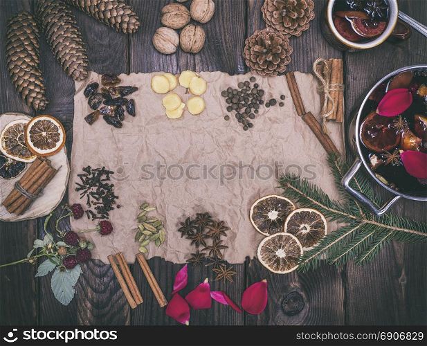 Ingredients and spices for the preparation of homemade liquor mulled wine on brown kraft paper, empty space in the middle, vintage toning