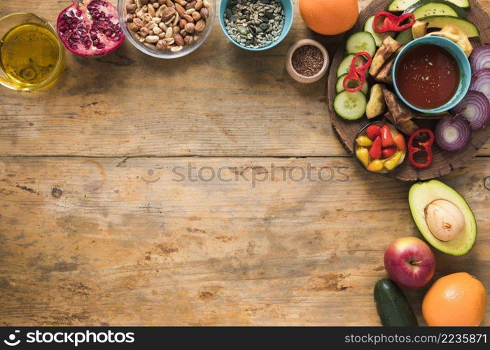ingredients dryfruits fruits oil sliced vegetables wooden table