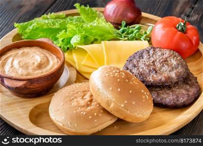 Ingredients for burgers on the wooden tray