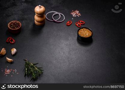Ingredients for cooking at home  pepper, salt, rosemary, spices and herbs on a dark concrete background. Ingredients for cooking at home  pepper, salt and rosemary