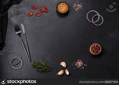Ingredients for cooking at home: pepper, salt, rosemary, spices and herbs on a dark concrete background. Ingredients for cooking at home: pepper, salt and rosemary
