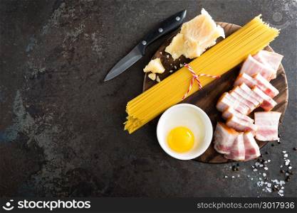 Ingredients for cooking Carbonara pasta, spaghetti with pancetta, egg and hard parmesan cheese. Traditional italian cuisine. Pasta alla carbonara