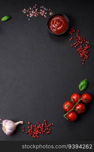 Ingredients for cooking cherry tomatoes, salt, spices and herbs on a dark concrete background